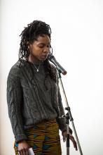 Omikemi, eyes shut, standing at microphone